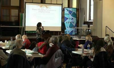 Second Baptist Church Eliminating Racism.  A woman speaks at the front of a room filled with seated participants