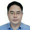 Portrait of an Asian man against a white background. He is looking directly at the camera with a slight smile and is wearing glasses.
